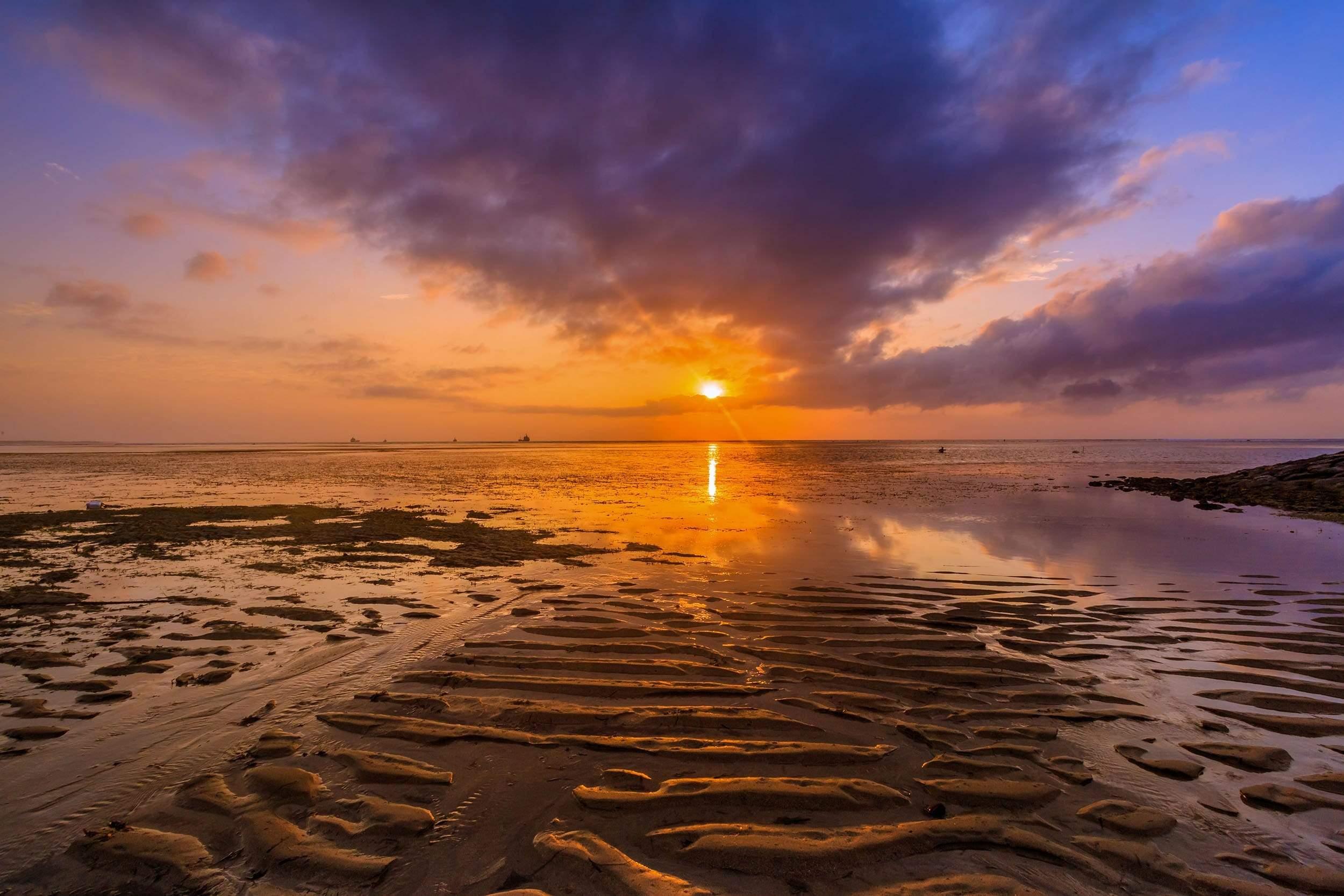 Sunset over shallow rippled sand