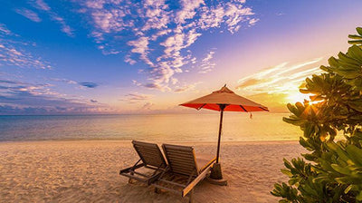 sunset image with two chairs on a beach