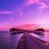 Sunset on Maldives island pier to water villas resort